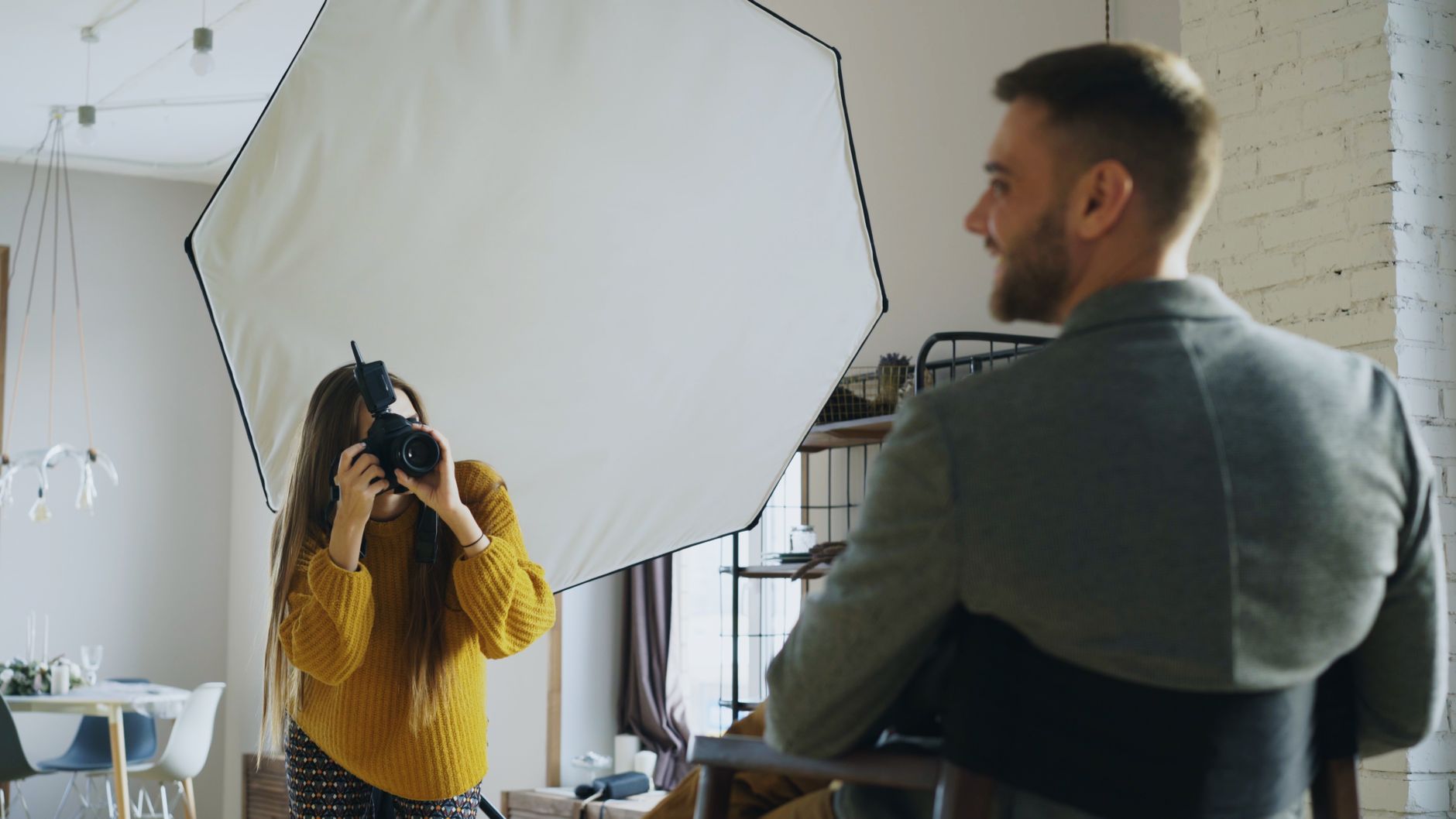 Fotógrafo analisando documentos de cobrança e contrato em mesa de trabalho